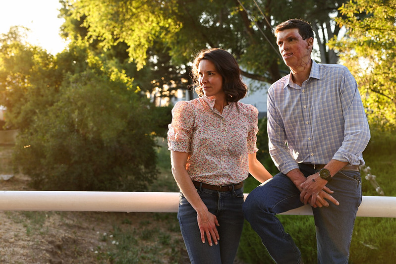 Sam and Amy Brown standing together outdoors at sunset